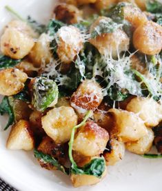 a white plate topped with pasta and spinach