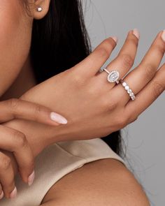 a close up of a woman's hand with a diamond ring on her finger