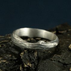 a silver ring sitting on top of a rock