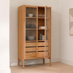 a wooden cabinet with glass doors and drawers in a living room or dining room area