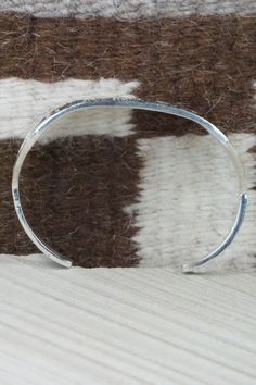 This sterling silver bracelet was made by Navajo silversmith Emerson Kinsel. The inside is signed K and stamped sterling.Size: 5 1/2" (will fit up to a 6 3/4" wrist)Gap: 1 1/4"Length: 7/8"Free shipping on all orders! We ship with USPS and always include tracking. All orders ship within a day of payment.Returns are accepted up to 30 days after you receive your order. Just send us a message. Our shop offers cash back or store credit. The item must be returned in new condition. Silver Artisan Bracelet, Southwestern Sterling Silver Polished Bangle Bracelet, Southwestern Sterling Silver Bangle With Polished Finish, Southwestern Polished Sterling Silver Bangle, Artisan Sterling Silver Bracelet With Oyster Detail, Artisan Sterling Silver Oyster Bracelet, Sterling Silver Bracelet, Native American Jewelry, Free Jewelry