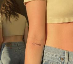 two women with tattoos on their arms and one has the word love tattooed on her arm