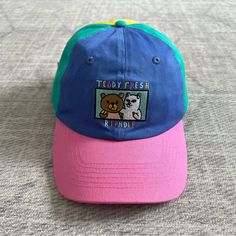 a blue and pink hat with a teddy bear patch on the front that says teddy fresh inside