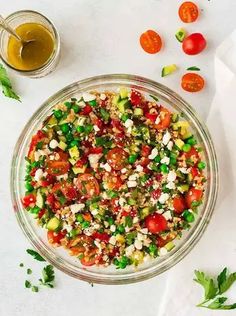 a glass bowl filled with vegetables and dressing