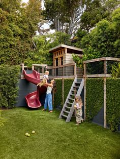 two children are playing in the backyard with a slide and climbing wall, while another child is standing next to it