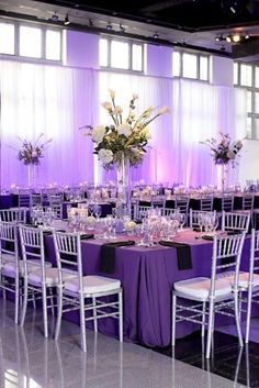 the tables are set with purple linens and white chairs