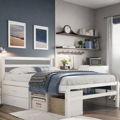 a white bed sitting in a bedroom on top of a hard wood floor next to a window