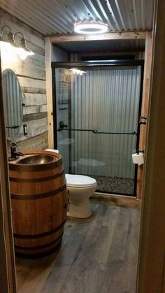 a bathroom with a wooden barrel next to a toilet