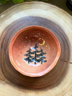 a small bowl with trees painted on it