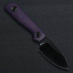 a purple knife on a black surface with the blade still in it's holder