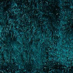 a close up view of the texture of a blue rug with green grass on it