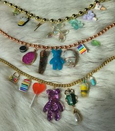 These cute chunky charm necklaces are super adorable and feature Crystal Gemstones on the copper necklace 💜 The copper necklace includes an oreo, Rainbow moonstone, teddy bear gummy, Tiger eye Pendulum, Pink Agate, slice of cake and green freeform jelly. Top necklace has a chunky plastic gold necklace includes some icecream pendants, butterfly, jelly dog and thunder bolt pendants  Bottom necklace  has a gold Cuban Link Chain and features a Victorian beetle pearl pendant, jelly bear, ice-cream, Lollipop, cake, locket and medicine pill All crystals are Sun Cleansed to purify & infused with positive energy. All stones are  Ethically Sourced Gemstones and ship from beautiful Pennsylvania. Crystal Chunk Necklace, Chickasaw Necklace, Trendy Handmade Crystal Necklaces, Quirky Multicolor Dangle Jewelry, Trendy Handmade Resin Necklace, Quirky Resin Jewelry For Gifts, Quirky Resin Jewelry As A Gift, Quirky Resin Jewelry Gift, Trendy Gold Resin Necklace