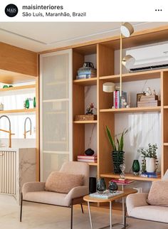 a living room with two chairs and a coffee table in front of a bookshelf