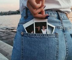 a person holding photos in their back pocket