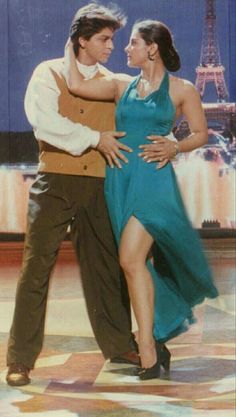 a man and woman dancing in front of the eiffel tower