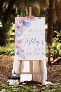 an easel with a sign that says welcome to ashley's baby shower