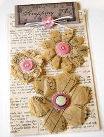 some paper flowers are sitting on top of an old book page, with buttons attached to them