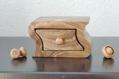 a wooden object sitting on top of a table next to two small wood balls in front of it