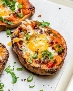 three baked potatoes with cheese and vegetables on them