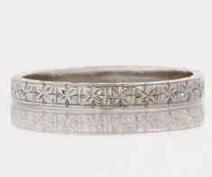 an antique wedding band with filigrees in white gold