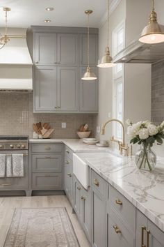 a kitchen with marble counter tops and gray cabinets