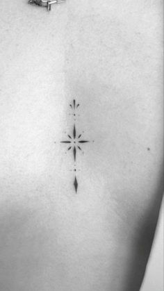 a black and white photo of a cross tattoo on the chest