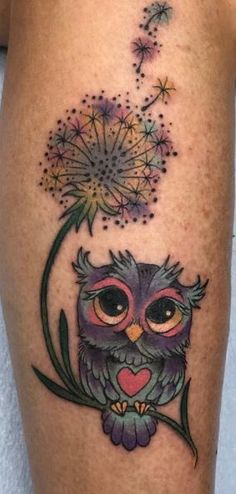 an owl sitting on top of a dandelion tattoo