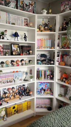 a white bookcase filled with lots of books next to a bed in a room