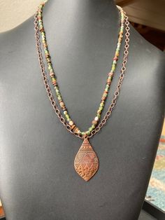 "An adjustable 19 3/4 to 22 1/4\" two strand necklace of matte rustic peridot, olive/sage green, bronze, and tan seeds beads,with satiny green/copper Czech glass beads, and accents of wood and copper. A second strand of copper cable chain lies alongside the first strand, with a tribal-style copper plated teardrop pendant hanging from the bottom. For lovers of more rustic jewelry, as well as Bohemian, tribal or ethnic style designs. Matching pieces available (see last photos) ~~Large Bali Tribal Olive Sage Green, Bohemian Chic Jewelry, Ruby Necklace Pendant, Earthy Jewelry, Rustic Jewelry, Art Deco Necklace, Hippie Jewelry, Style Fall, Seed Bead Necklace