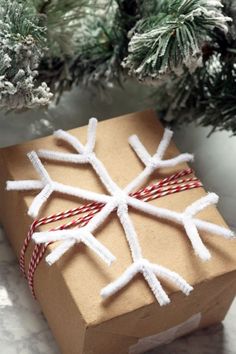 a present wrapped in brown paper with white snowflakes on it