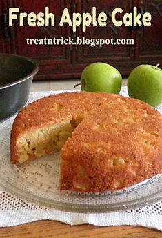 fresh apple cake on a glass plate with one slice cut out and two green apples in the background