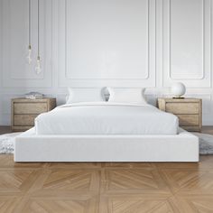 a white bed sitting on top of a wooden floor next to two nightstands and a lamp