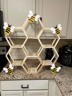 a kitchen counter with shelves made out of hexagonal honeycombs and bees on them