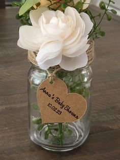 a mason jar filled with flowers on top of a wooden table