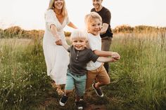 a group of people standing around each other in a field with one boy holding the hands of two women