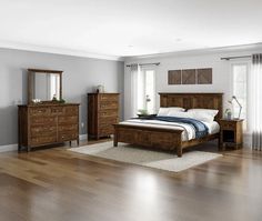 a bedroom scene complete with a bed, dresser and mirror on the wall - to - floor hardwood flooring