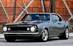 an old muscle car parked in front of a building