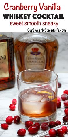 cranberry vanilla whiskey cocktail in a glass with ice and cranberries around it