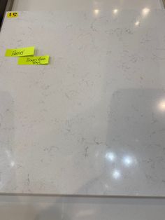 a white counter top with sticky notes on it