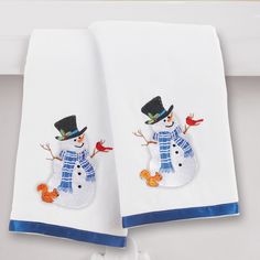 two towels with embroidered snowmen on them