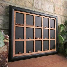 there is a wooden frame with words on it next to a potted green plant