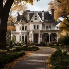 a large white house surrounded by trees and pumpkins