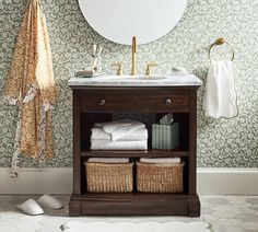 a bathroom with a sink, mirror and towels on the shelf in front of it