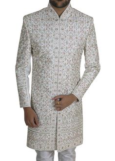 Step into the grandeur of your special day with our exquisite Hand-Embroidered 2 Pc Set Designer Wedding Men's Sherwani in luxurious White Silk. This ensemble transcends mere clothing, offering a royal experience that commands the spotlight. Meticulously crafted with precision, the finest silk envelops you in comfort and unrivaled elegance. The allure of this ensemble lies in the intricate hand embroidery and zari work that adorn its regal canvas. Each stitch tells a story of timeless craftsmanship, creating an awe-inspiring masterpiece that reflects sophistication and grandeur. The richness of the embroidery resonates with tradition, infusing your look with a sense of regal charm fit for a king. This Sherwani set is more than just a garment; it is a statement of style and refinement. The Embroidered Bollywood Sherwani With Traditional Fit, Traditional Fit Embroidered Bollywood Sherwani, Bollywood Style Embroidered Sherwani, Bollywood Style Ceremonial Sherwani With Traditional Fit, Traditional Fit Sherwani For Wedding And Diwali, Traditional Fit Bandhgala For Wedding, Wedding Sherwani For Diwali, Embroidered Traditional Fit Sherwani For Wedding, Traditional Fit White Embroidered Sherwani