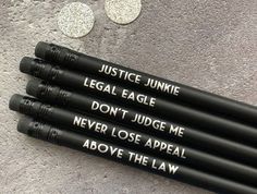 four black pencils with white writing on them