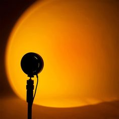 a light that is sitting on top of a pole in front of a yellow background