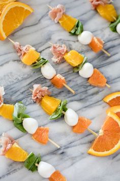 oranges and other fruits are arranged on skewers