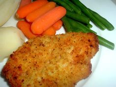 chicken schnitz, carrots, celery and green beans on a white plate