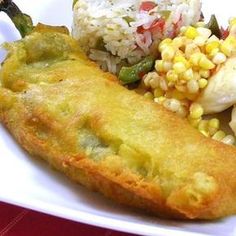 a white plate topped with fried food and rice