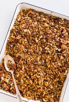 a white dish filled with granola on top of a table